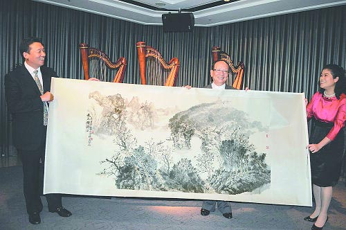 刘君代表桂林市向蒋孝严赠送桂林山水画。